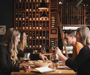Guests enjoying a meal with wine at Flights. 