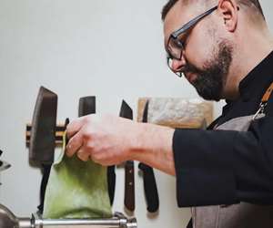 Chef preparing fresh pasta dish. 